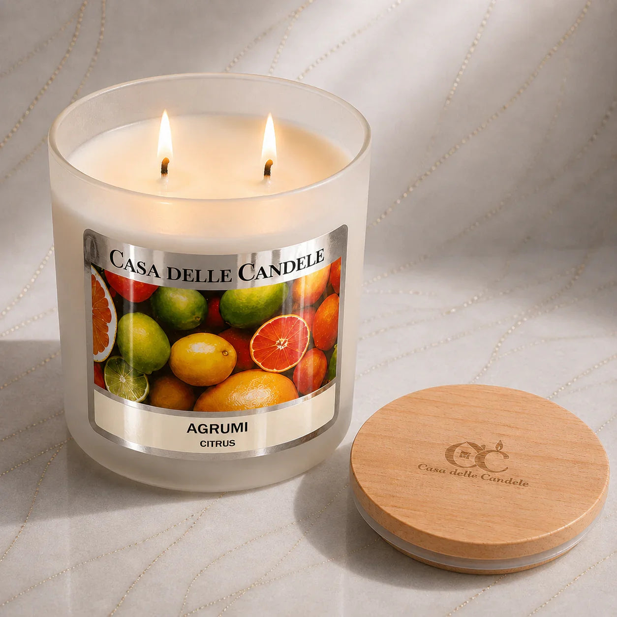candela in cera di soia agrumi 430g accesa su marmo