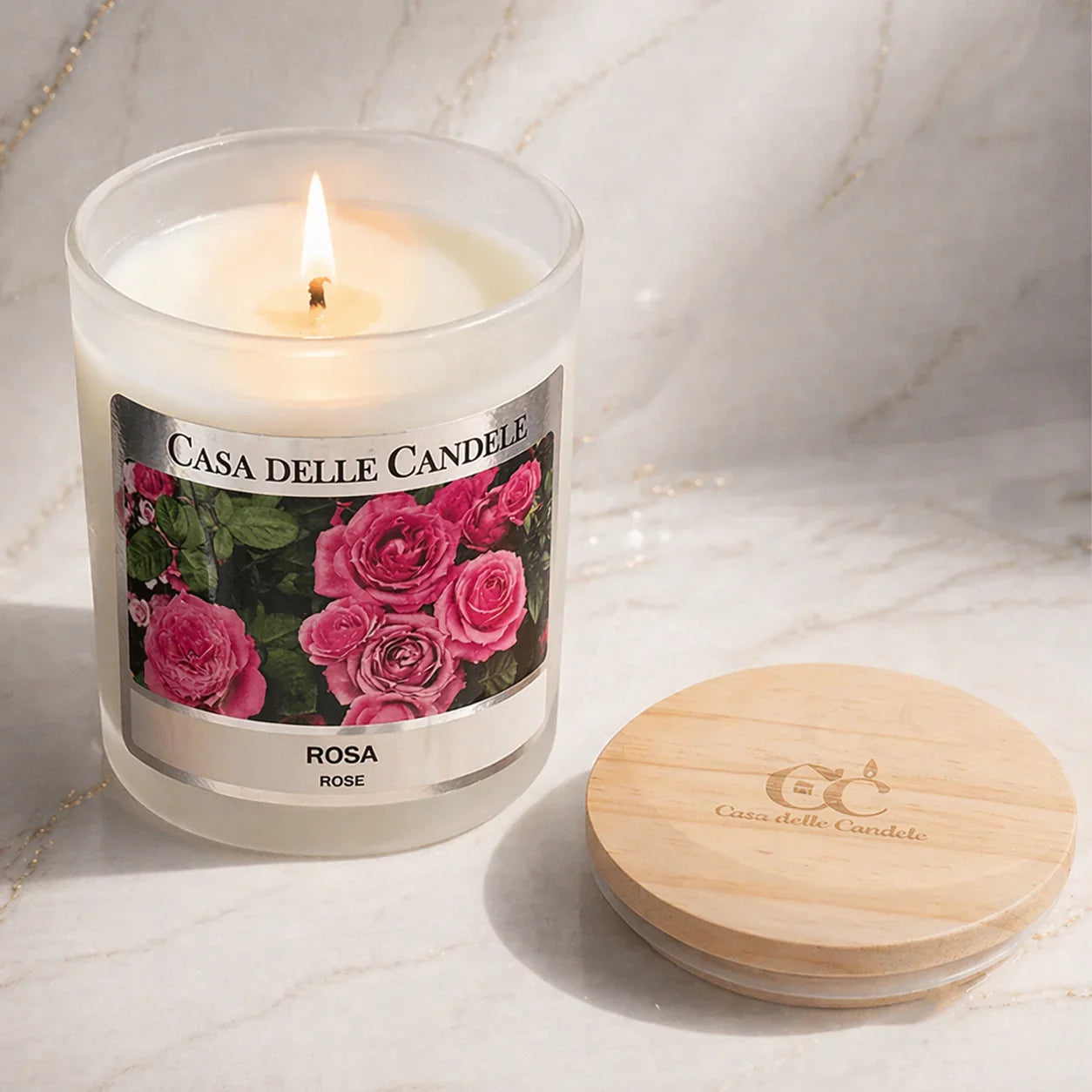 candela in cera di soia rosa accesa ambiente elegante su marmo